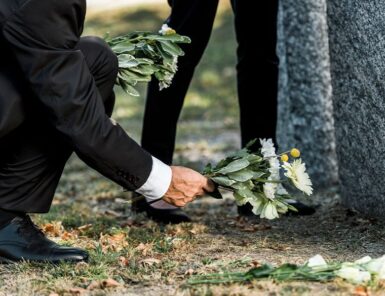 Quelqu'un pose un bouquet de fleurs sur une tombe
